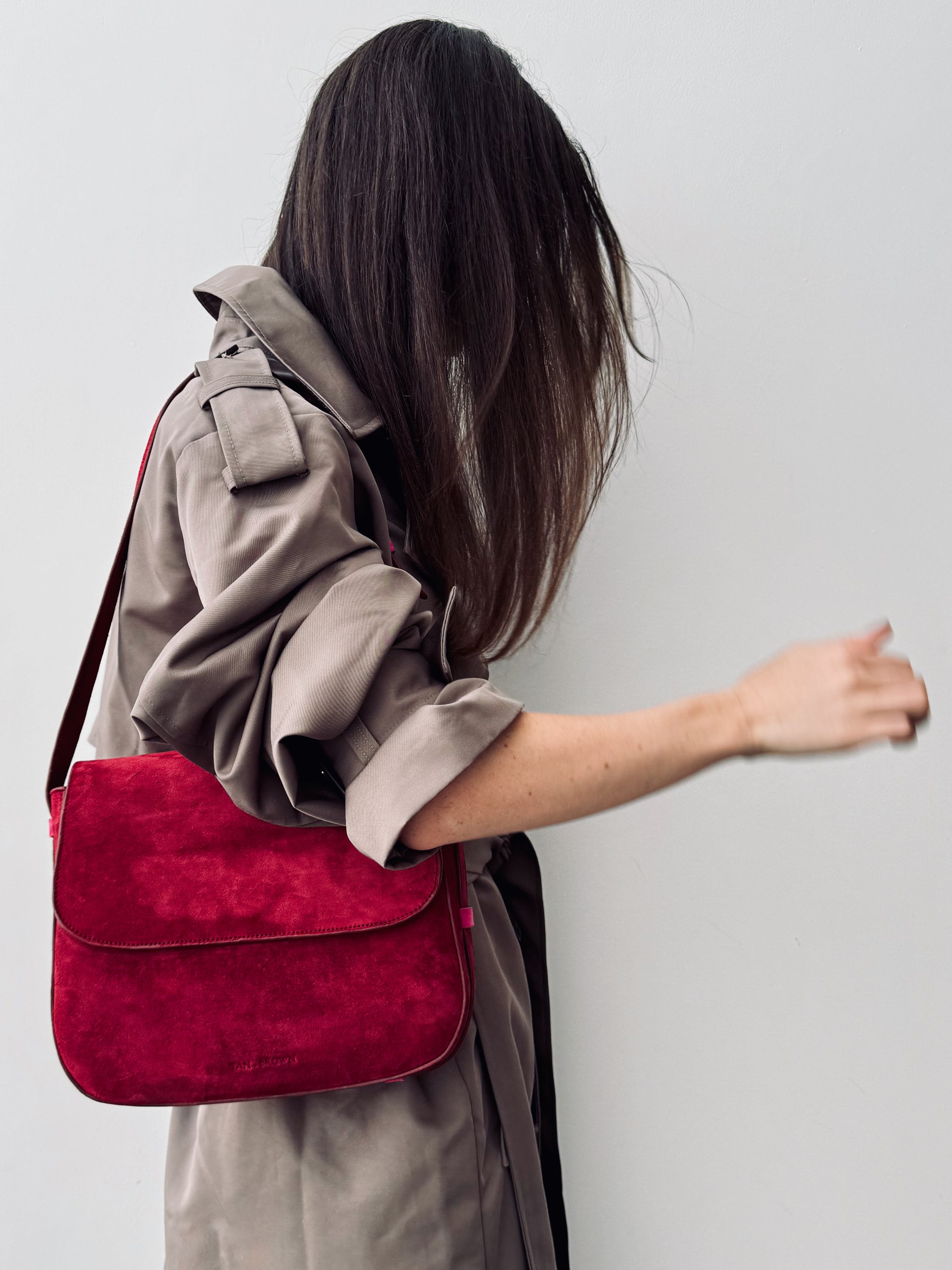 Person wearing a red bag over their shoulder against a plain background